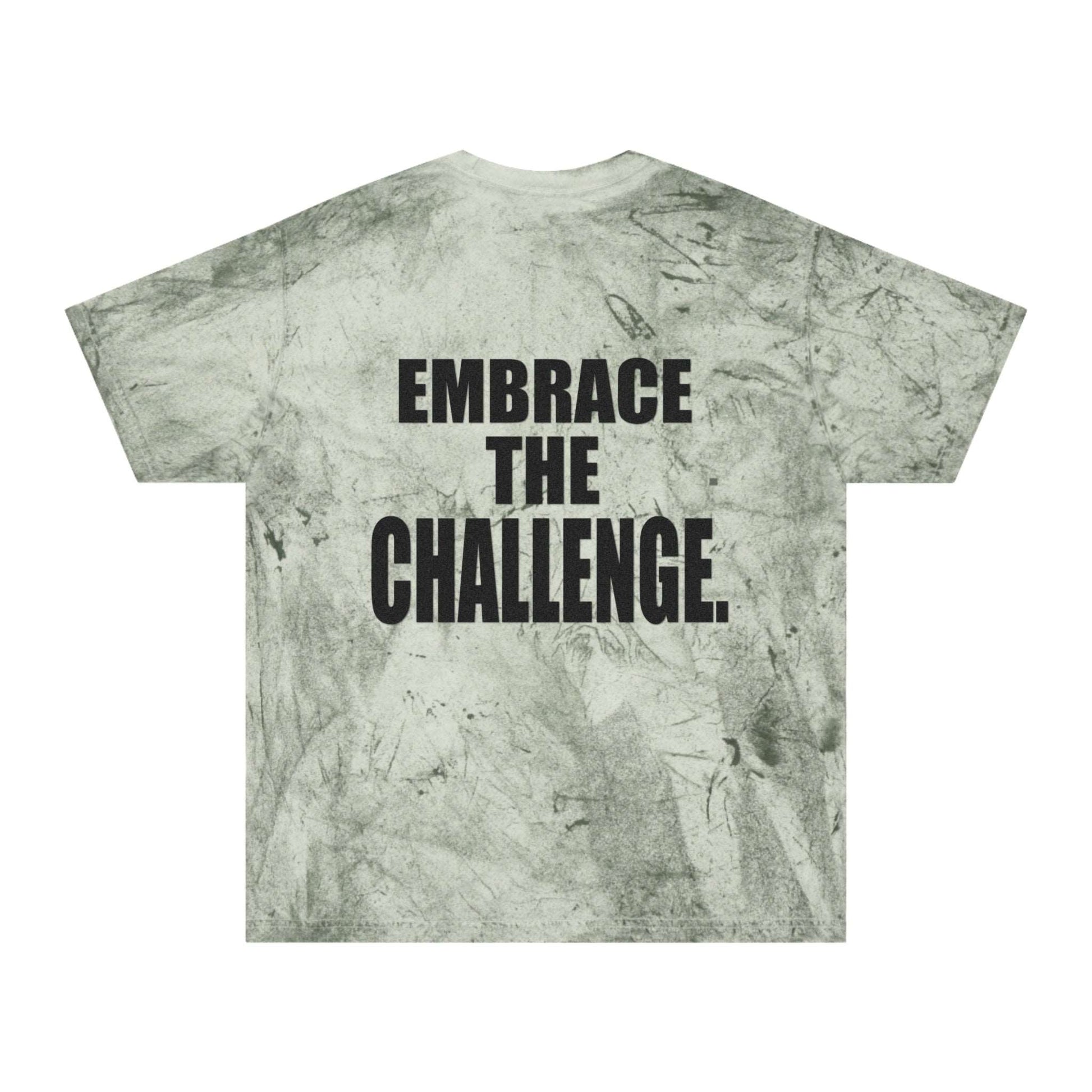 A green tie-dye t-shirt with a textured pattern reminiscent of a medieval shirt, featuring a motivational message in bold black letters that reads "Embrace the Challenge" on the back.