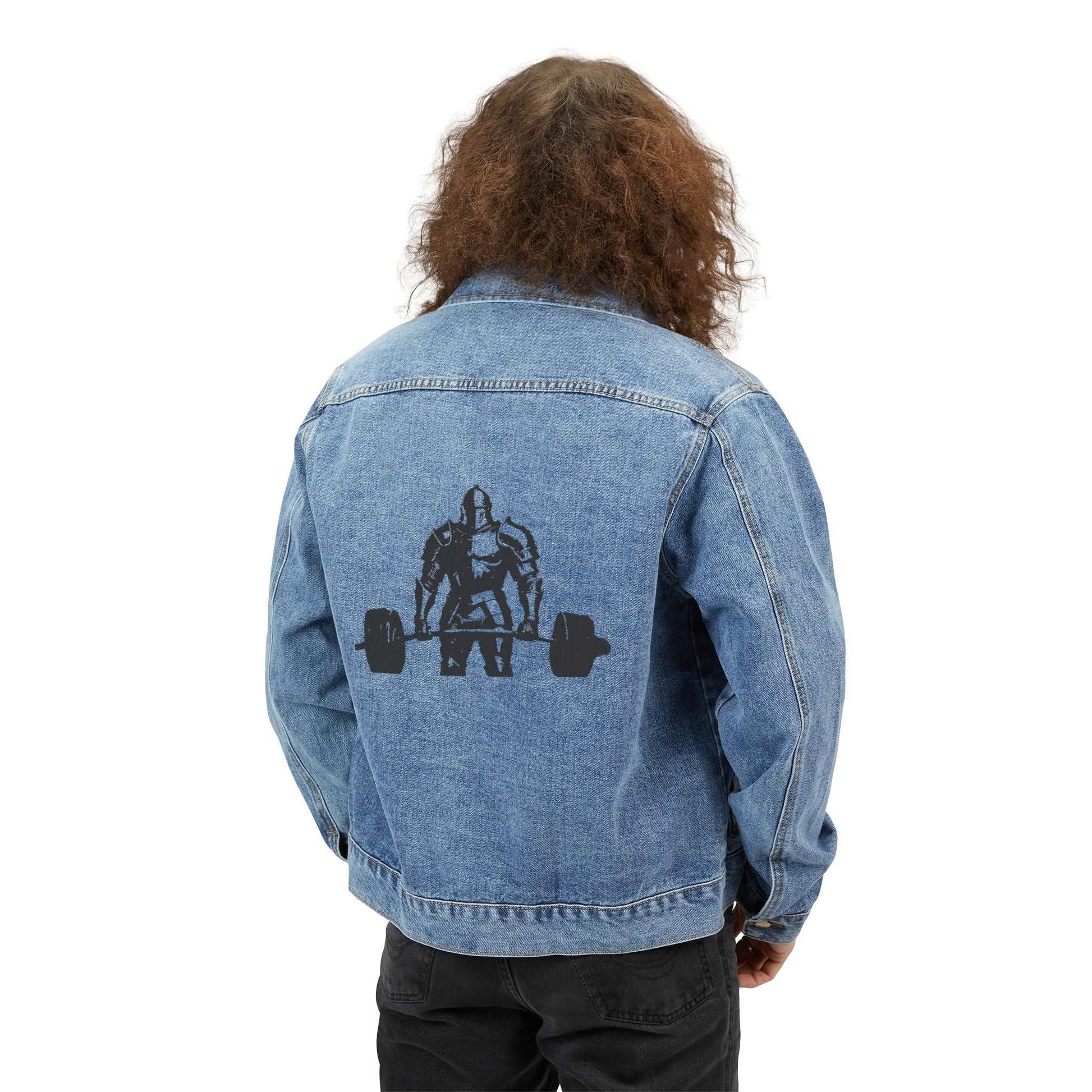 The back view of a person with long curly hair is wearing a denim jacket over a white shirt and dark pants, standing against a plain white background. 