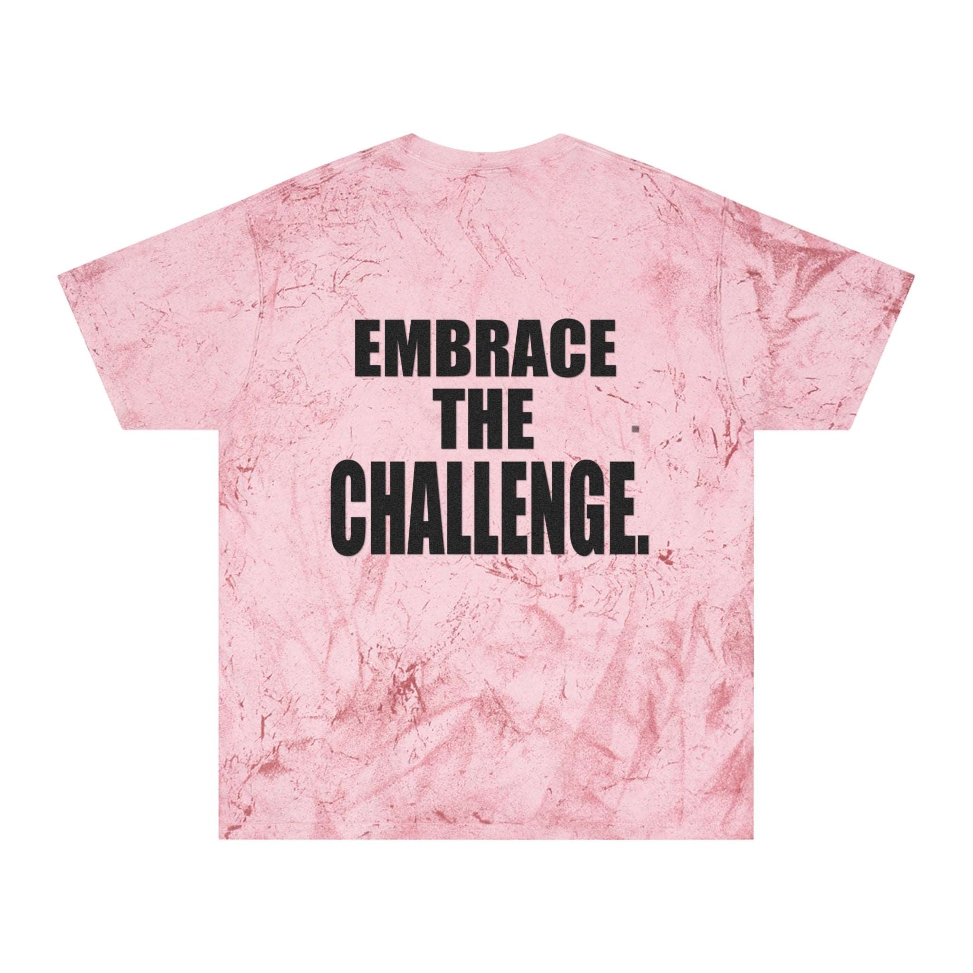 A pink tie-dye t-shirt with a textured pattern reminiscent of a medieval shirt, featuring a motivational message in bold black letters that reads "Embrace the Challenge" on the back.